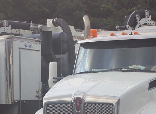 Vacuum tubes and boom stowed above the cab of a Kenworth T880 hydrovac
