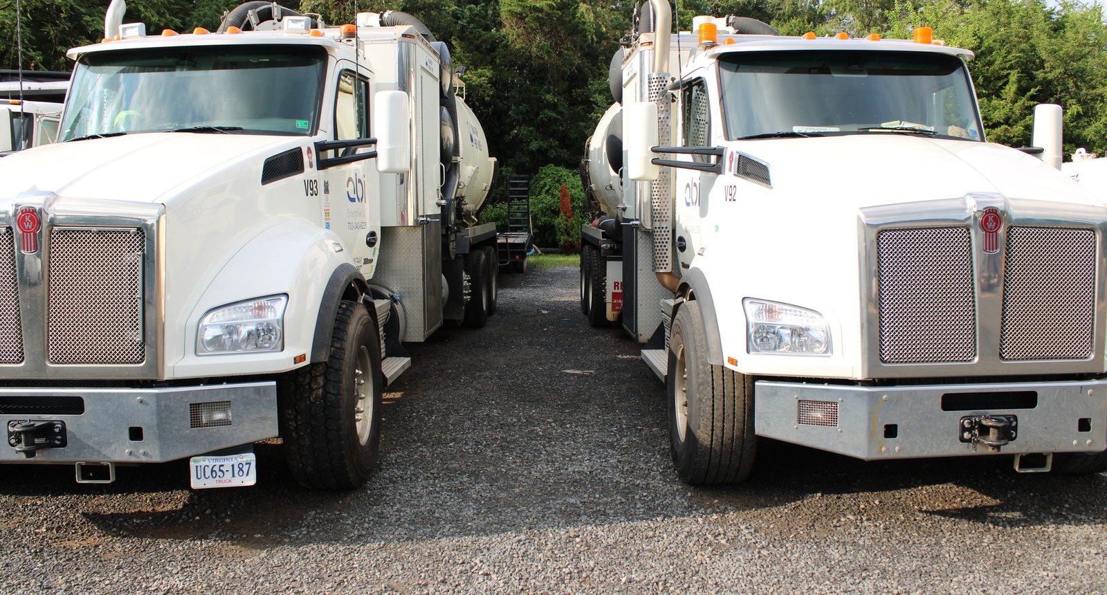 Both ABI hydrovac trucks parked nose-out on the gravel yard